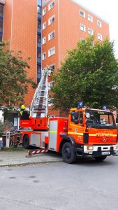 Drehleiter in Stellung gebracht, die Trage ist im Fenster
