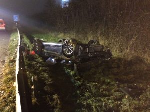 Der zweite Unfallwagen kopfüber hinter der Leitplanke