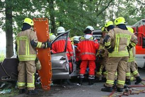 Im Vordergrund ist das orange-farbige Rettungsbrett, mit dem der Patient gleich aus dem Fahrzeug gehoben wird, zu erkennen