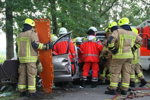 Im Vordergrund ist das orange-farbige Rettungsbrett, mit dem der Patient gleich aus dem Fahrzeug gehoben wird, zu erkennen