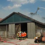 Zum Schutz des Stallgebäudes mussten lange Schlauchleitungen um den gesamten Gebäudekomplex herum verlegt werden. Die 24 Jungbullen brauchten zum Glück nicht herausgeführt werden, da der Wind den Brandrauch nicht bis zu Ihnen vordringen ließ (Foto: Michae