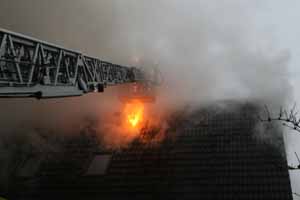 Nach dem Entfernen von Dachpfannen schlagen offene Flammen aus dem Dach