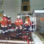 Vor dem Eingang des Objektes steht ein Rettungstrupp sowie die Leitung Atemschutz bereit