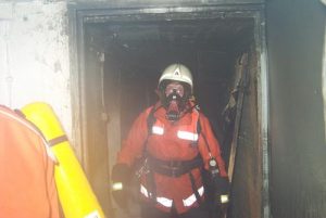 Zwei Atemschutzgeräteträger verlassen den Keller nach dem das Feuer aus war