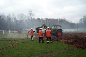 Der Bagger hat den Haufen abgetragen und mit dem Trecker des Geschädigten wurde der Mist zum Ablöschen auf der angrenzenden Weide verteilt