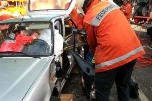 Mit dem hydraulischen Rettungsspreizer wird die Tür auf der Fahrerseite entfernt. Das Unfallopfer ist zum Schutz mit einem Laken abgedeckt und wird im Fahrzeug während der gesamten technischen Rettung betreut