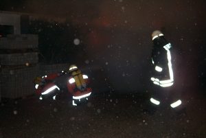 Der erste Angriffstrupp löscht den LKW, unter schwerem Atemschutz per Schnellangriff ab