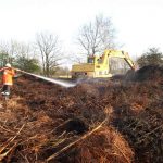 Ein Bagger wurde angefordert und per Tieflader an den Hunnenbarg gebracht. Mit Treckern hätte das auseinander Reißen des Haufens zu lange gedauert