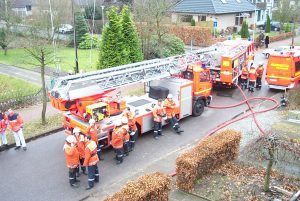 Kräfte der Feuerwehr Pinneberg und des Rettungsdienstes in Wartestellung während der Gebäudeüberprüfung nach Glutnestern