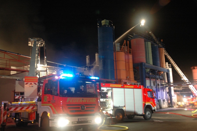 Im Hintergrund die Brandbekämpfung über die Pinneberger Drehleiter, im Vordergrund wird der Teleskopmast aus Elmshorn für den Einsatz vorbereitet