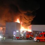 Die Halstenbeker Drehleiter ist zum Schutz der Lagerhalle links sowie zur Brandbekämpfung eingesetzt