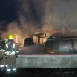 Ein Atemschutztrupp auf dem Dach der Lagerhalle bei der Bekämpfung des Feuers in der Produktionshalle
