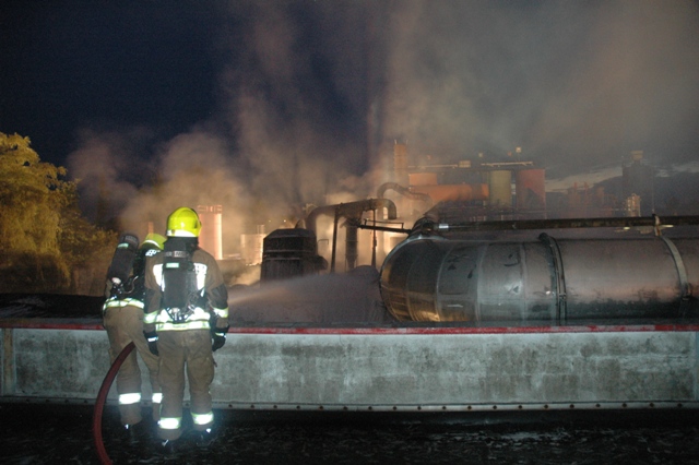 Ein Atemschutztrupp auf dem Dach der Lagerhalle bei der Bekämpfung des Feuers in der Produktionshalle