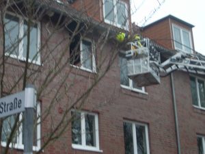 Der Korb der Drehleiter steht in Anleiterbereitschaft zur Sicherung des Atemschutztrupps im Innenangriff.