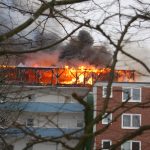 Blick von der Rückseite des Gebäudes, das Dachgeschoß steht im Vollbrand.