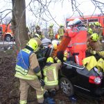 Die Rettung des Fahrers mithilfe eines Spineboards wird vorbereitet.