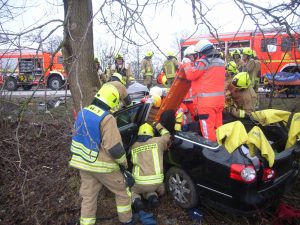 Die Rettung des Fahrers mithilfe eines Spineboards wird vorbereitet.