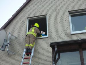 Die Kinder werden durch einen Feuerwehrmann beruhigt.