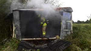 Nachlöscharbeiten, nachdem die komplette Seitenwand des Bauwagens entfernt wurde