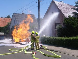 Der Druckluftschaum klebt an der Fassade und bildet eine Isolierschicht gegen die Wärmestrahlung der Gasflamme